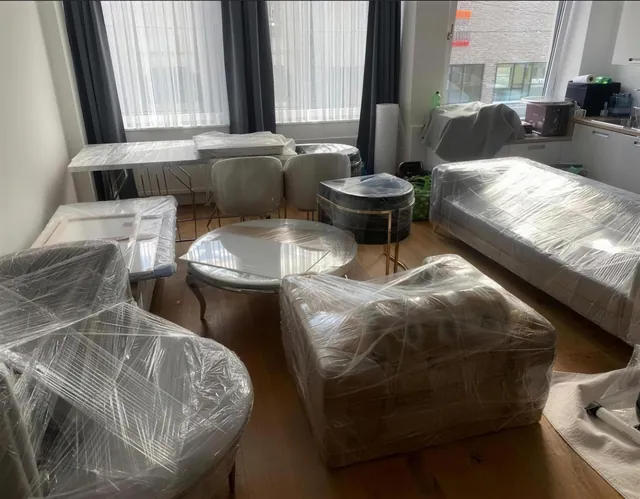 Sofa, Sessel und Tische in Stretchfolie verpackt, bereit zum Abtransport.